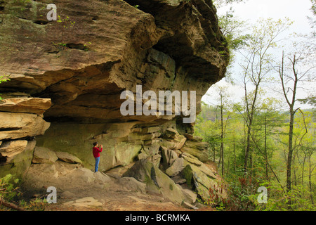 Hiker takes picture below Whistling Arch Red River Gorge Geological Area Slade Kentucky Stock Photo
