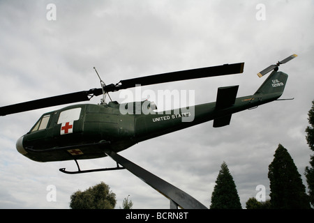 A dustoff Huey helicopter which flew in the Vietnam War is perched on a pole at a memorial in Porterville, California. Stock Photo
