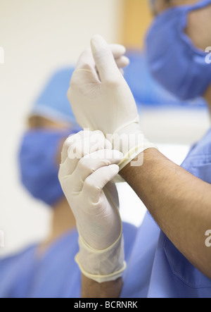 Surgeon putting on gloves Stock Photo