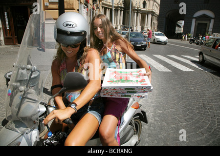 Two girls on a scooter taking home pizza in Naples Italy Stock Photo