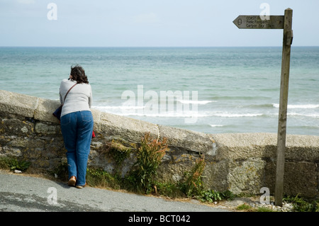 A female tourist on the South West Coast Path at Charlestown, Cornwall, England Stock Photo