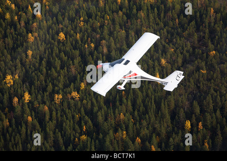 airplane over northern forest Stock Photo