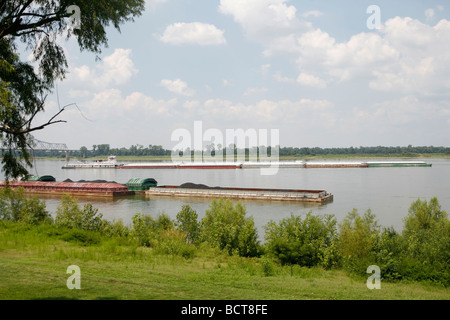 A barge pushes up the Mississippi River where the Ohio and the Mississippi rivers meet seen from Cairo, Illinois. Stock Photo