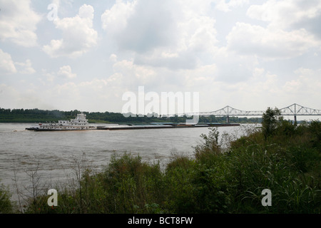 A barge pushes up the Mississippi River where the Ohio and the Mississippi rivers meet seen from Cairo, Illinois. Stock Photo