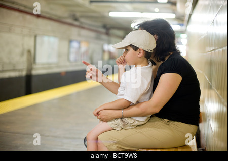 Hispanic mother and three and a half (3 1/2) year old son wait for the subway train in Boston MA Stock Photo