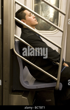 Tired young man on a New York City subway train Stock Photo