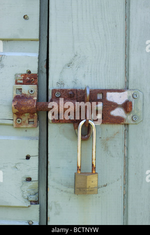 Sliding bolt on a blue wooden shed, secured with a Minster padlock. Stock Photo