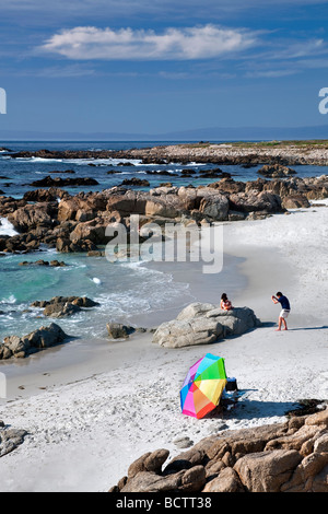 Beach umbrella and beach with man taking picture of family 17 Mile Drive Pebble Beach California Stock Photo