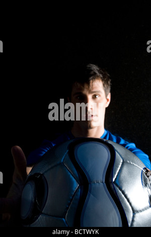 Portrait of a young man showing a soccer ball Stock Photo - Alamy