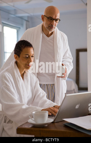 https://l450v.alamy.com/450v/bctyt9/side-profile-of-a-mature-woman-using-a-laptop-with-a-mature-man-standing-bctyt9.jpg