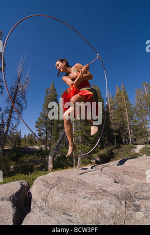 Woman practicing with a lariat in a forest Stock Photo