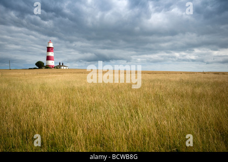 Happisburgh lighthouse with dark cloudy skies and fields of wheat  in Norfolk East Anglia England Stock Photo