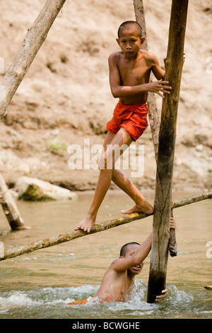 Young Buddhist Monks cool off in the Nam Khan river, Luang Prabang, Laos Stock Photo