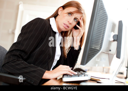 Woman stressed at computer Stock Photo