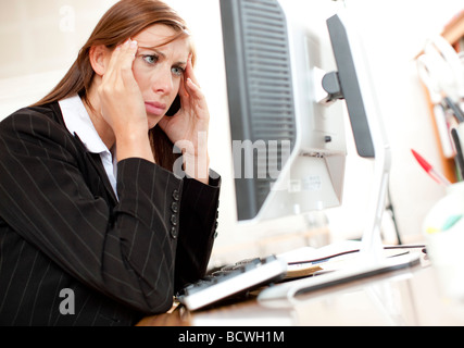 Woman stressed at computer Stock Photo