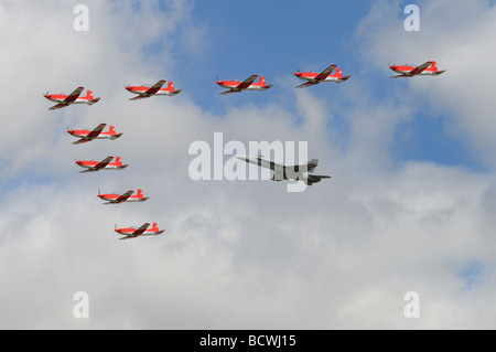 The Swiss Air Force aerobatic display team in their prop powered Pilatus trainers in formation with a Swiss F-18 Hornet jet Stock Photo