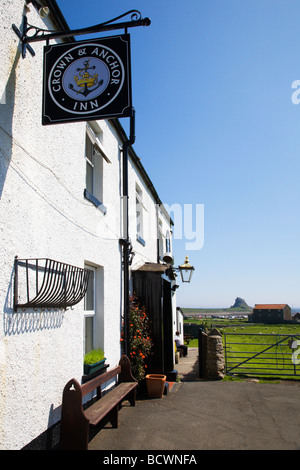 Crown and Anchor pub with the castle in the distance Lindisfarne Stock Photo