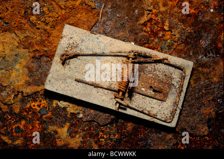 Old mousetrap on rusted iron plate Stock Photo