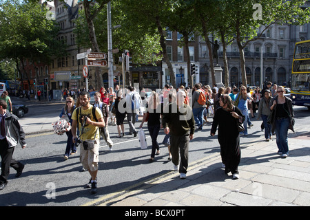 tourists crossing a busy street junction on college green in dublin city centre republic of ireland Stock Photo