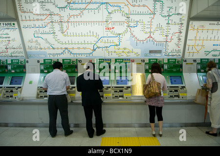 Commuters retrieving ticket at an automatic vending machines in a subway entrance gate. Central Tokyo Japan Stock Photo