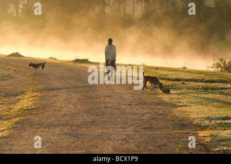 An Indian man wrapped in a shawl walks by the Bhadra River in the Chikmagalur District of Karnataka, India. Stock Photo