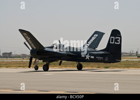 A Grumman Tigercat taxis on the runway as it begins to fold its wings upward Stock Photo