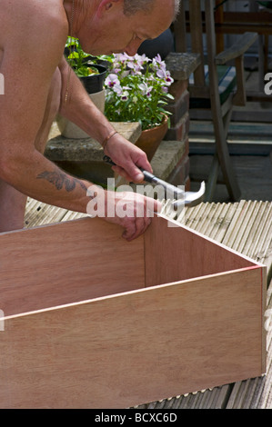 Handyman Constructing a Wooden Box Stock Photo