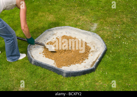 Woman Mixing Cement and Ballast With a Shovel Stock Photo