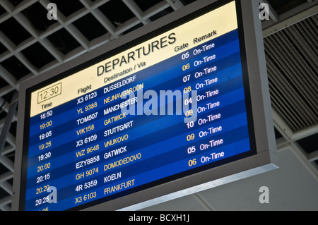 Flight departure information board at airport Stock Photo