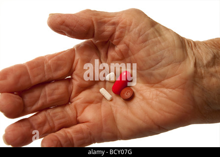 Elderly womans hand holding pills Stock Photo