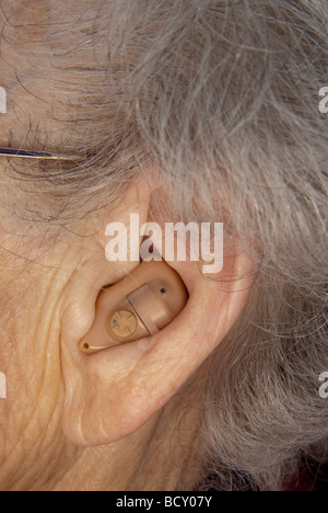 Hearing aid on an elderly woman Stock Photo