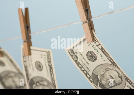dollars hanging on line on blue background Stock Photo