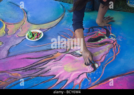 Young female artist working on pastel painting in the park. Stock Photo