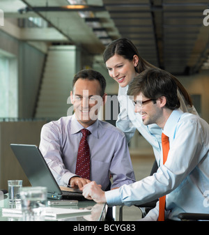 Three Businesspeople looking on laptop Stock Photo