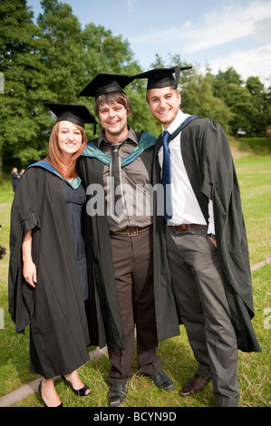 Three Ex students wearing gown and mortar board on Graduation day Aberystwyth University Wales UK Stock Photo