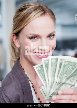 woman holding up dollar bills Stock Photo