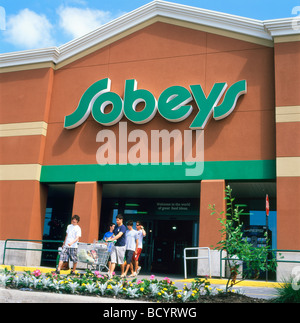 Shoppers people family food shopping at Sobeys supermarket entrance open 24 hours store with shopping cart trolley Ontario Canada  KATHY DEWITT Stock Photo