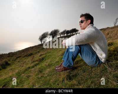 man looking at view on coastal hill Stock Photo