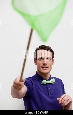 man playing with butterfly net Stock Photo