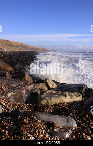 Waves crashing onto rocks at Barton on Sea beach, near New Milton, Hampshire, with views across to the Isle of Wight. Stock Photo