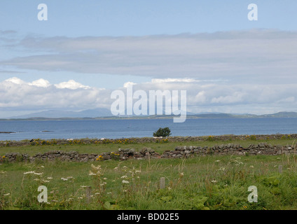 View of the Scottish island of Gigha taken from the main A83 on the mainland and the Paps of Jura in the background Stock Photo