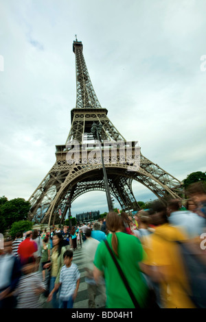 A crowd crosses the street in front of the Eiffel Tower Stock Photo