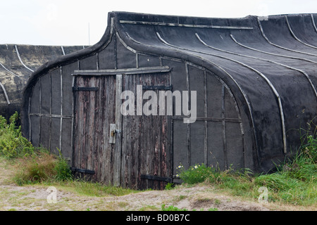 Upturned boat hull, now used as shed Stock Photo