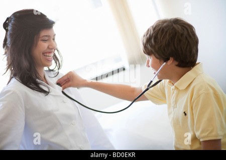 Boy listening to female Doctors heart Stock Photo