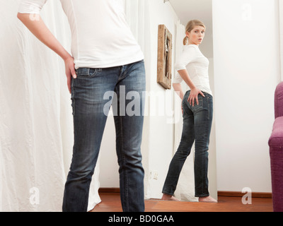 Woman checking her body in the mirror. Stock Photo