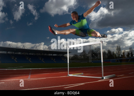 athlete jumping hurdle Stock Photo