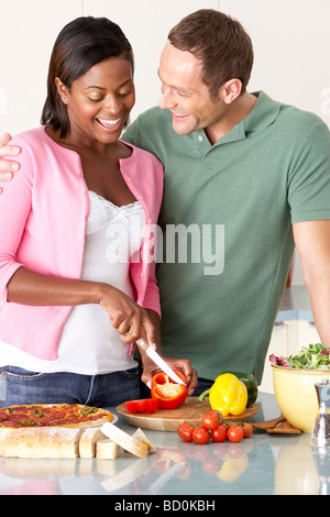 Young Couple Preparing Meal In Kitchen Stock Photo