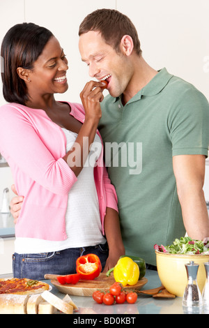 Young Couple Preparing Meal In Kitchen Stock Photo