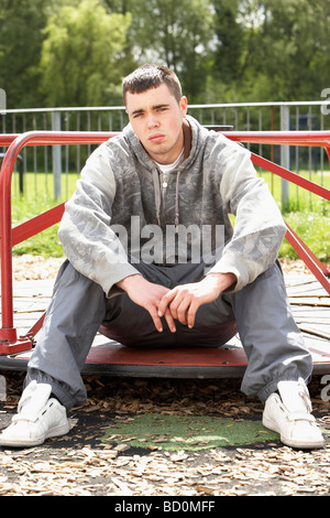 Young Man Sitting In Playground Stock Photo