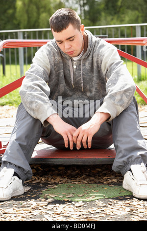 Young Man Sitting In Playground Stock Photo